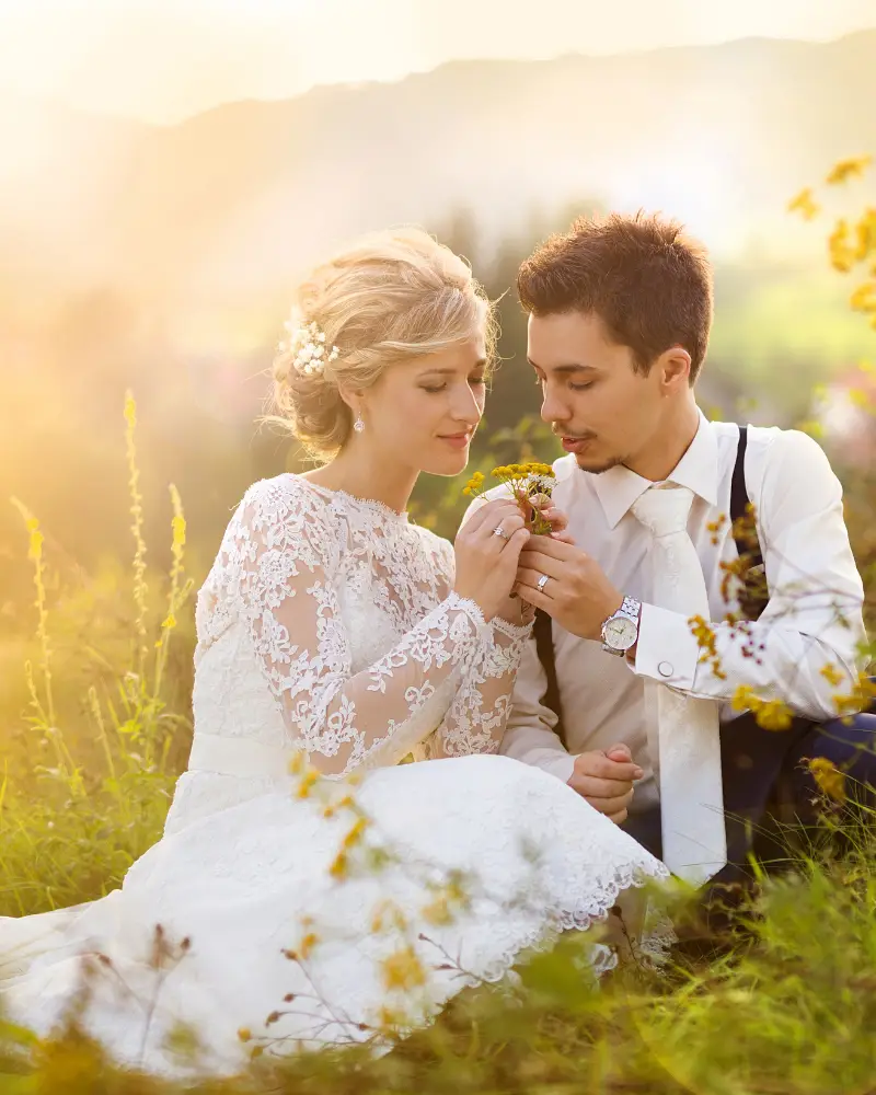 Zelf je bruiloft plannen, maar met een beetje hulp van mij (Femke) op de achtergrond. Ik ben geen typische weddingplanner, maar help jou terug naar rust en overzicht om weer heerlijk in jullie bruidsbubble te komen en relaxt je eigen bruiloft te organiseren. Foto: bruidspaar tijdens fotoshoot. Bruidegom geeft bruid een geplukte bloem uit het veld waar ze in zitten.